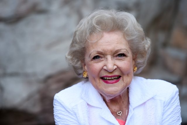 betty white laughing in white jacket and pink shirt