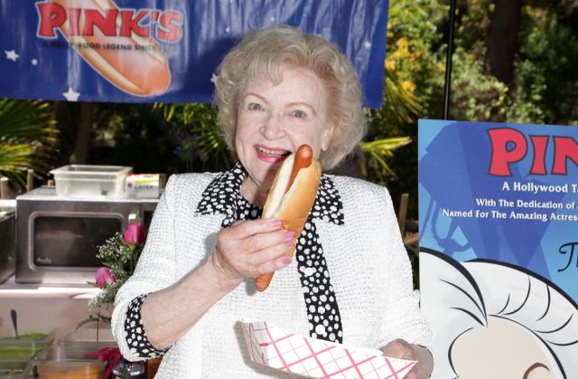 betty white holding a hot dog outdoors