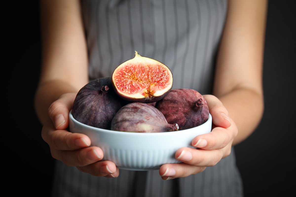 woman holding a bowl of figs