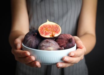 woman holding a bowl of figs