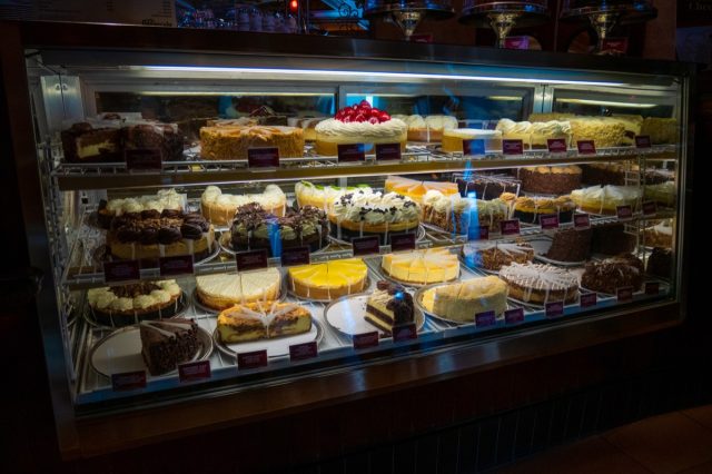cheesecakes in a dessert case at cheesecake factory