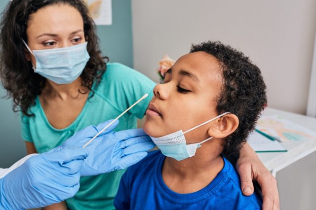 African American little boy with his mother during PCR test of coronavirus in a medical lab