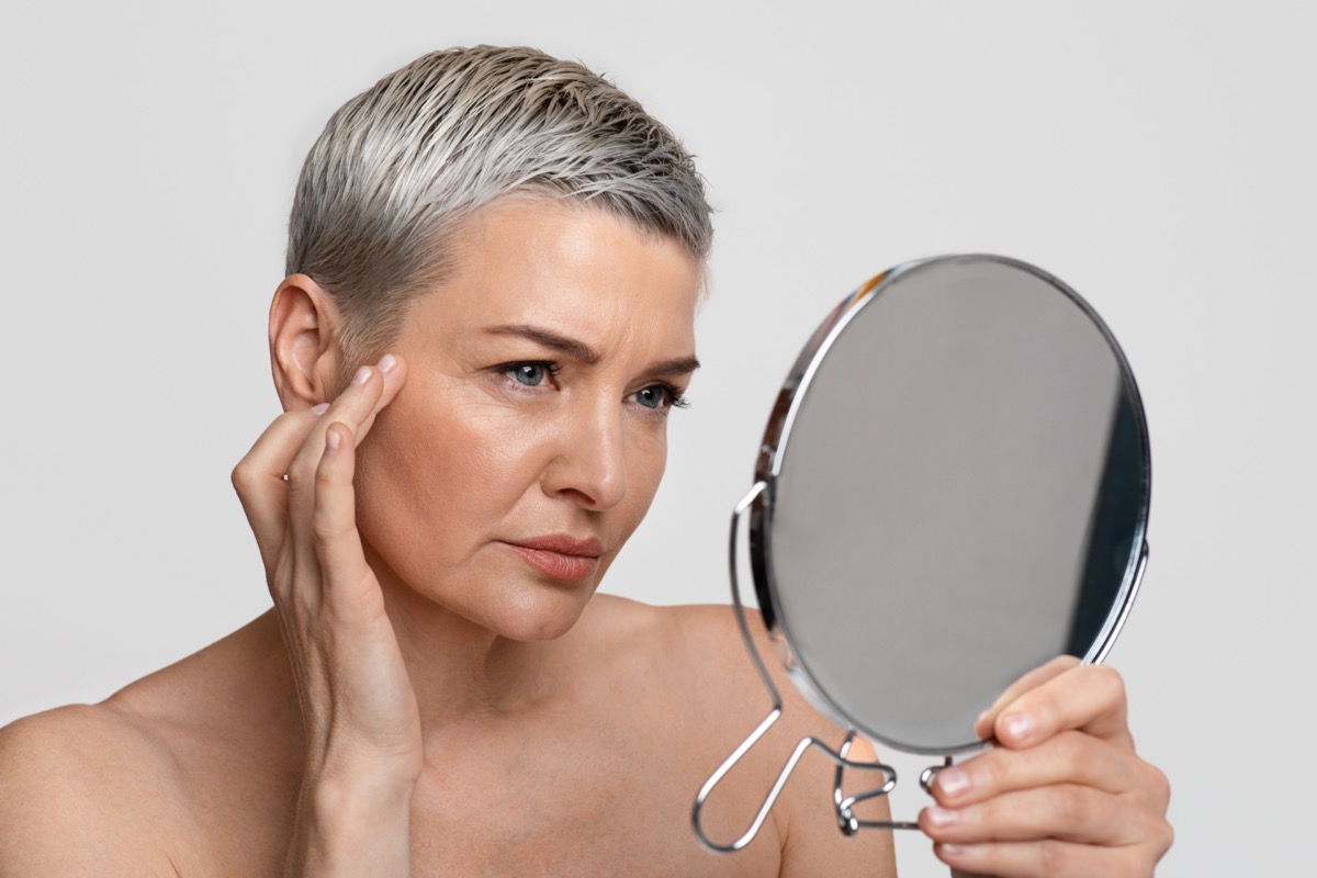 Mature woman mirror skin face aging