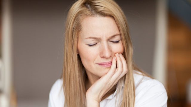 Mature woman feeling strong pain, toothache.