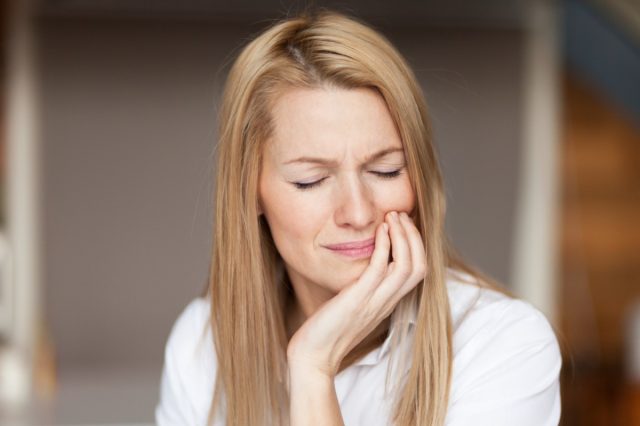 Mature woman feeling severe pain, toothache.