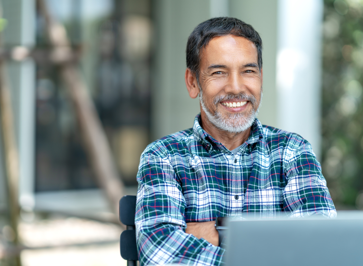 Older man using laptop smiling