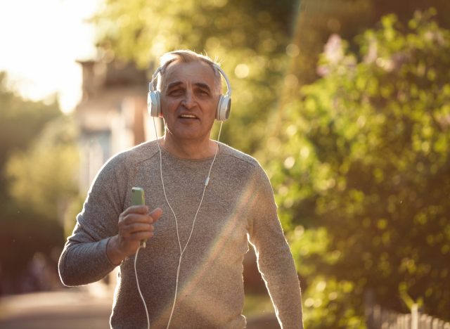 older man walking headphones