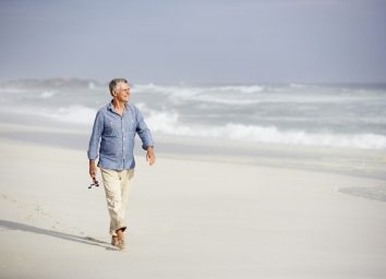 older man walking on the beach