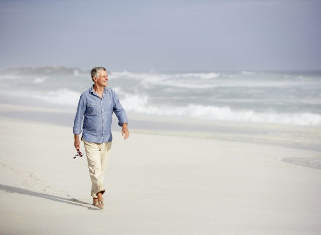 older man walking on the beach