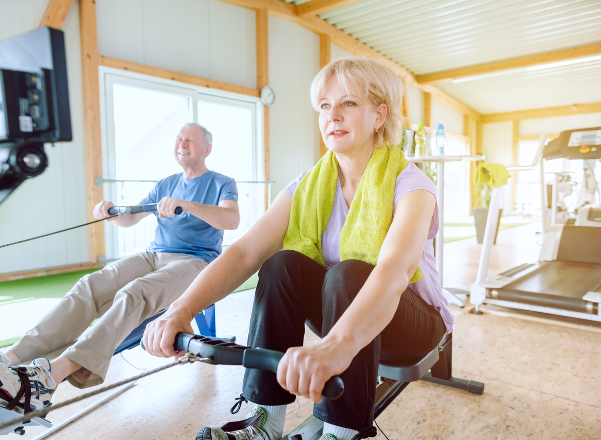 older woman man rowing machines