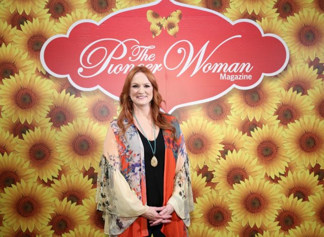 ree drummond in floral silk top standing against sunflower backdrop