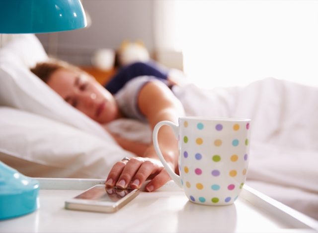 Sleeping Couple Being Woken By Mobile Phone In Bedroom
