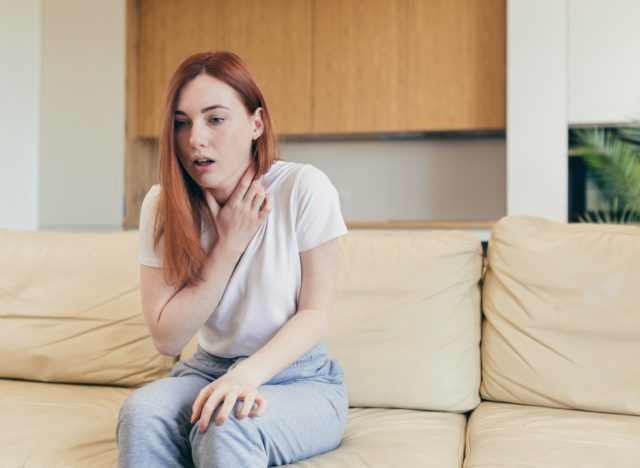 Woman suffering an anxiety sitting on a couch.