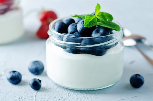 yogurt in small glass pot topped with blueberries