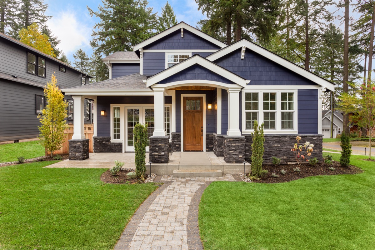 modern blue house with front lawn in suburbs