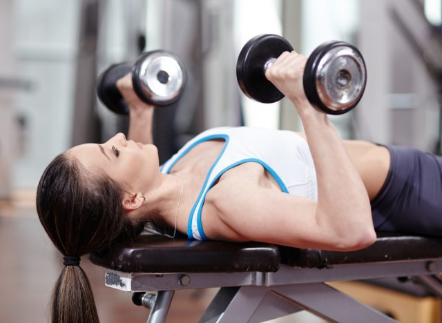 woman doing chest press exercise on workout bench