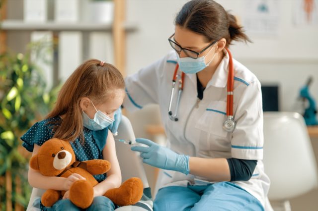 Doctor vaccinating child at hospital.