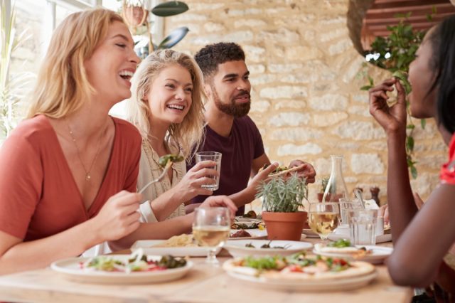 young friends eating together at restaurant