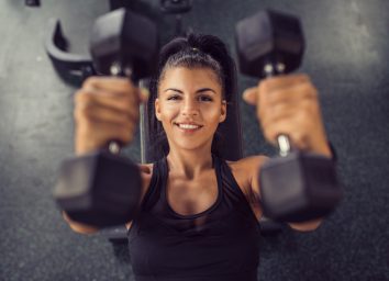 happy woman smiling gym weights