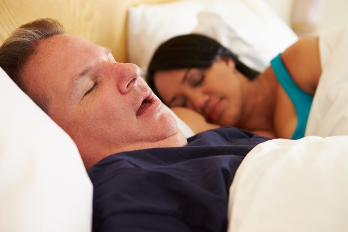 middle aged man and woman sleeping in bed