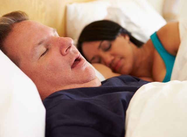 middle aged man and woman sleeping in bed