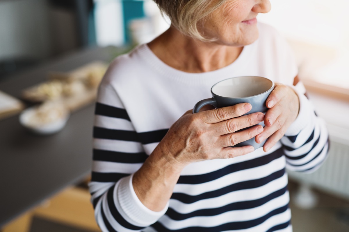 older woman in striped top drinking coffee