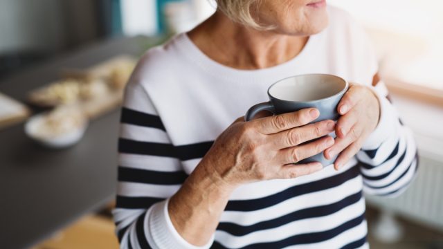 older woman in striped top drinking coffee