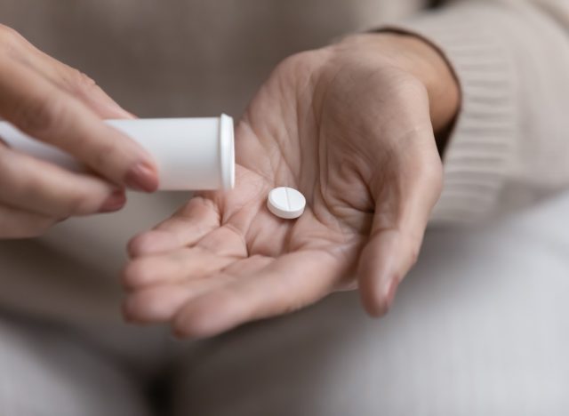 older woman taking pill or supplement