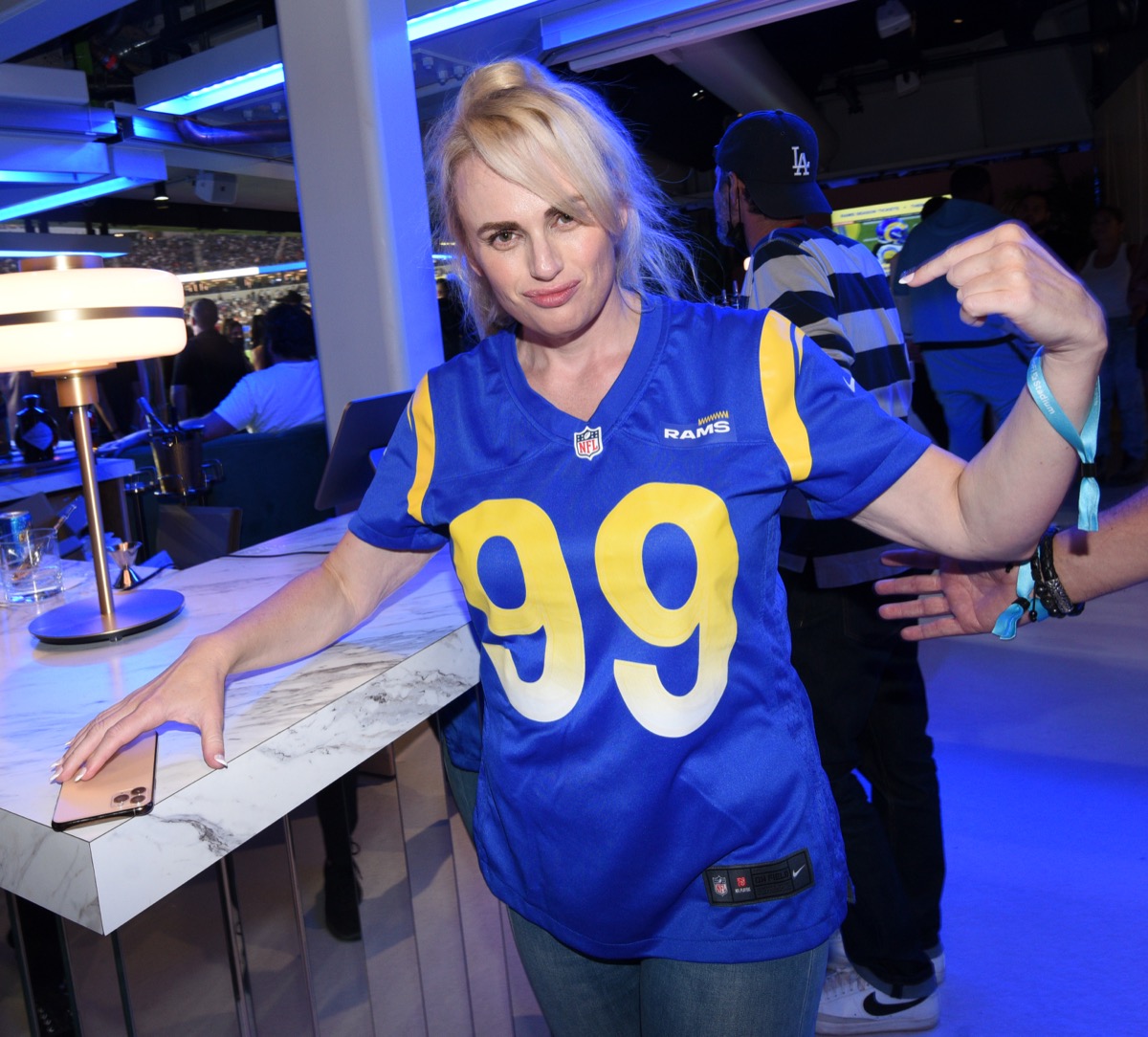 rebel wilson in blue football jersey pointing at herself