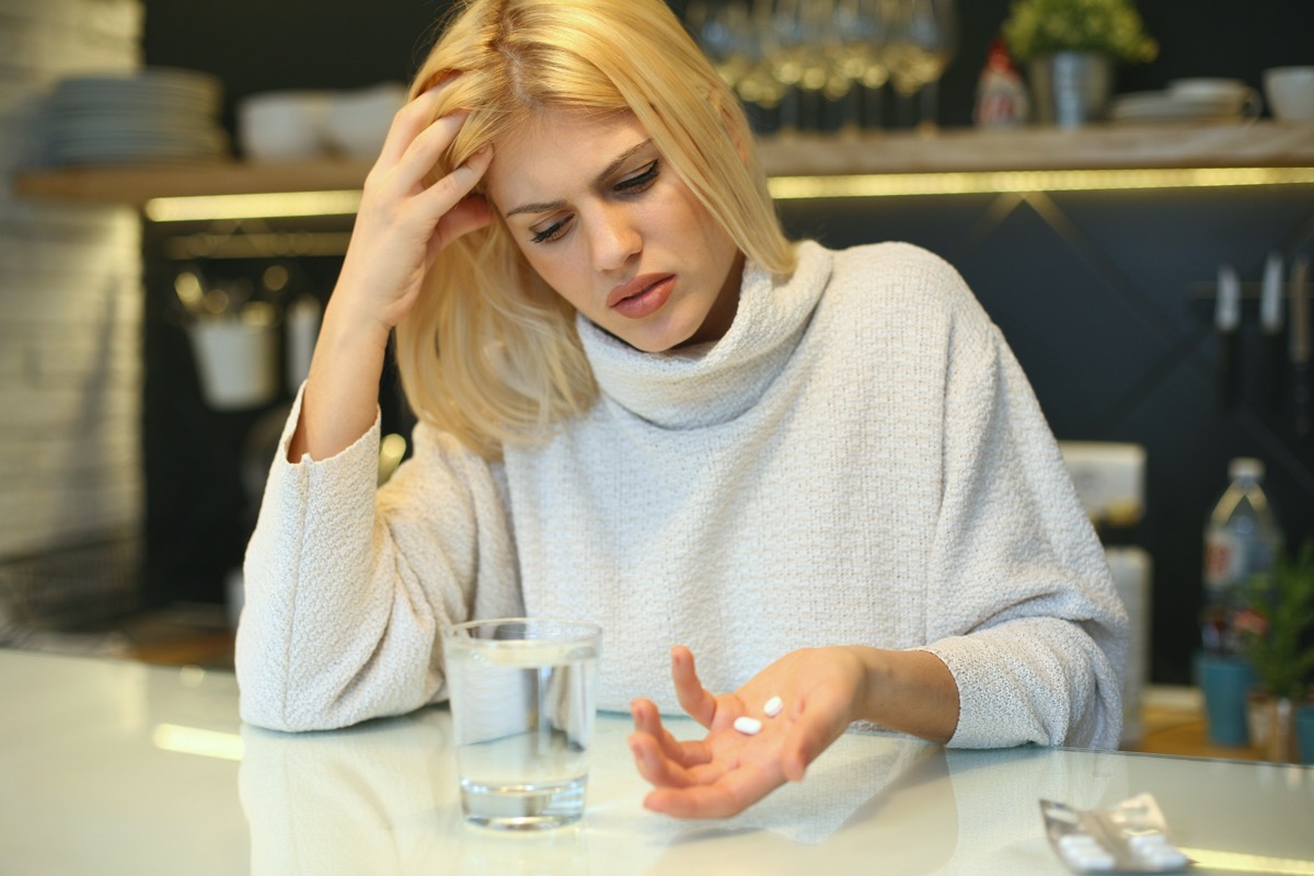Woman holding pills in her hands.