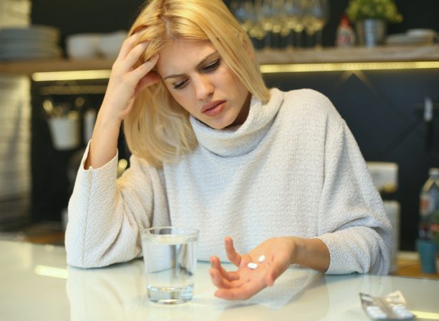Woman holding pills in her hands.