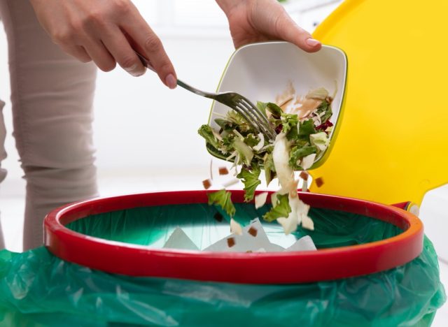 throwing salad away in trash can