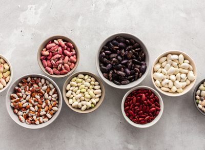 Different types of beans in bowls, economically important legume, top view