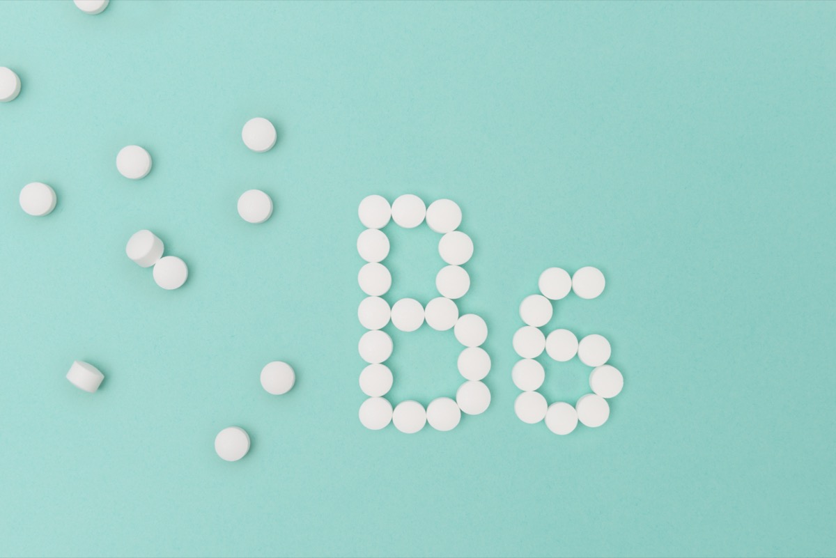 Vitamin B6 pills forming the word 'B6' over turquoise background.