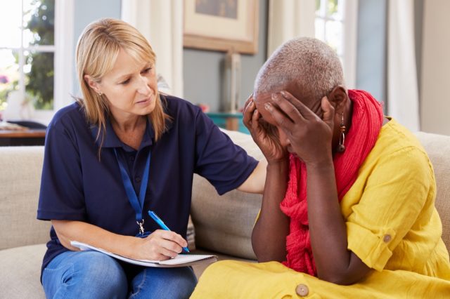 Femeie de vârstă mijlocie cu pierderi de memorie, boală Alzheimer sau demență vorbește cu medicul sau asistenta la domiciliu