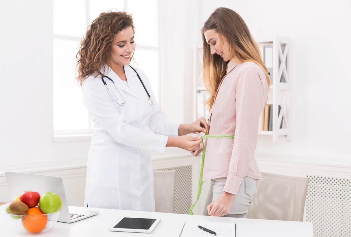 Woman weight loss doctor measuring tape