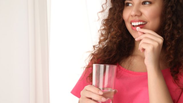 young woman taking pill