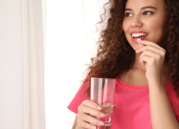 young woman taking pill