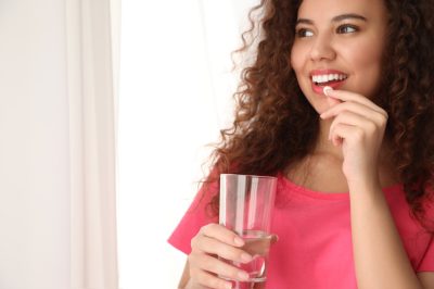 young woman taking pill