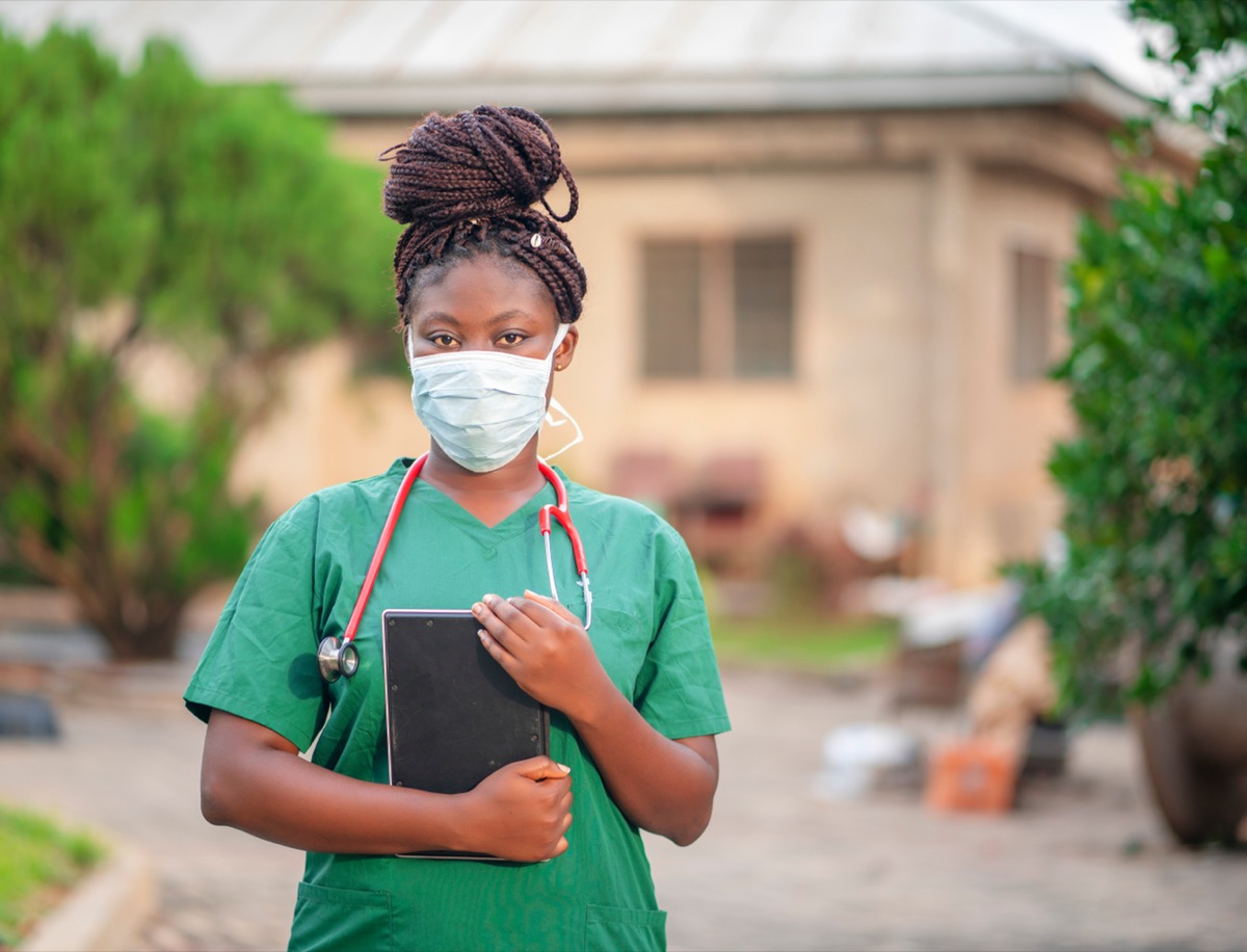 African health worker holding tablet with her stethoscope around the neck