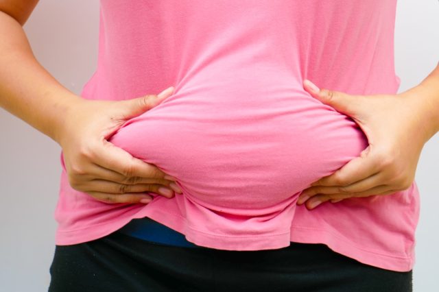 A woman squeeze her tummy