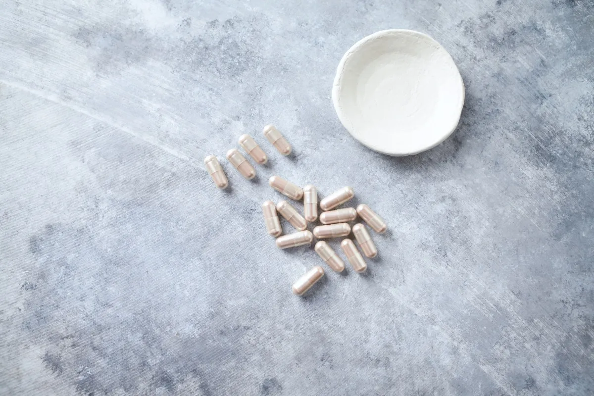 l-carnitine supplements next to a white bowl on a gray background