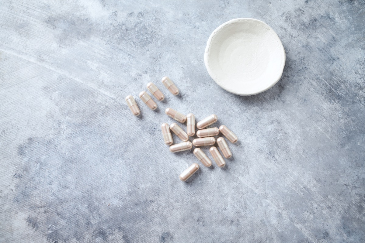 l-carnitine supplements next to white bowl on gray background