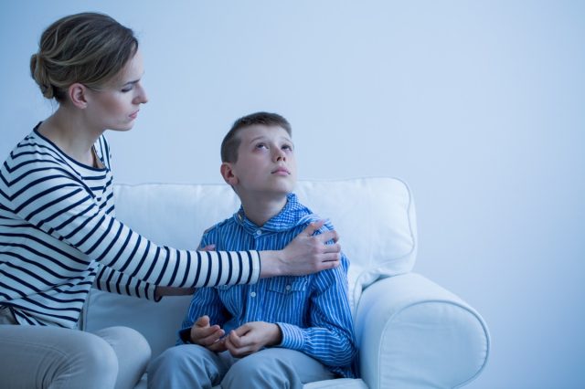 Mother and her autistic son sitting on the sofa