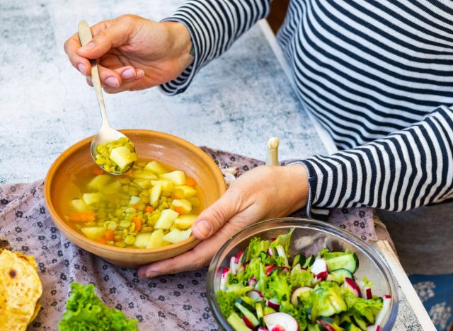 eating soup with spoon and salad