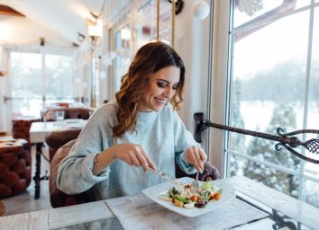 happy woman eating salad at a restaurant