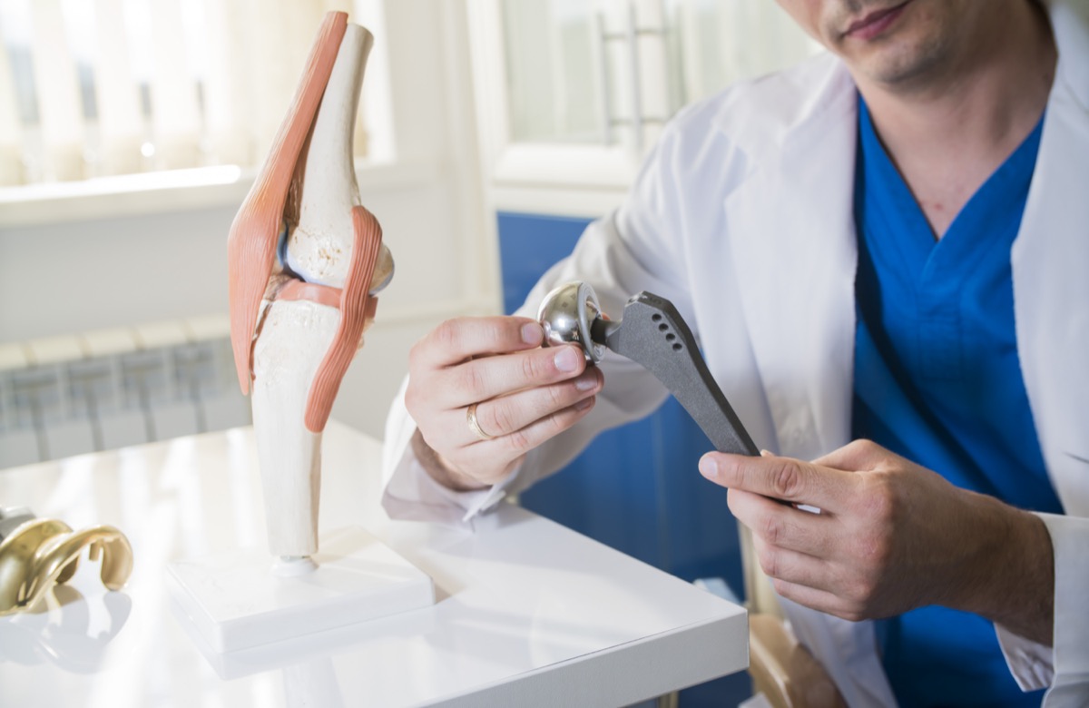 Doctor holds implant of the hip joint.