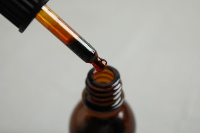 Dripping medical iodine from pipette into glass bottle