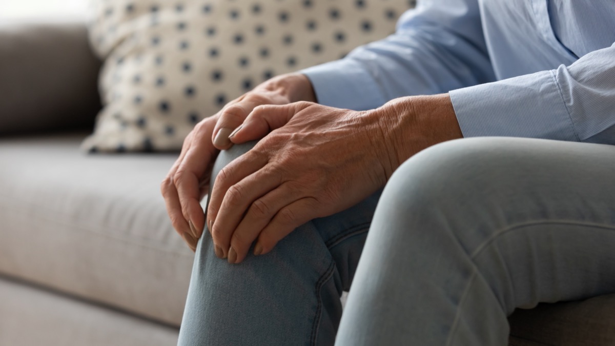 older woman on couch with knee pain