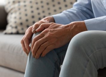 older woman on couch with knee pain